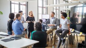 comment améliorer la communication interne - une équipe au bureau en train de discuter tous ensemble