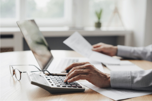Professionnel gérant la comptabilité avec ordinateur et calculatrice