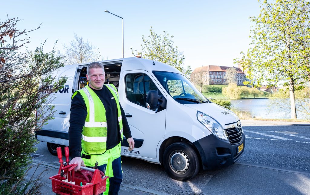 Technicien terrain avec ses outils près de son véhicule utilitaire, illustrant la gestion des déplacements en entreprise