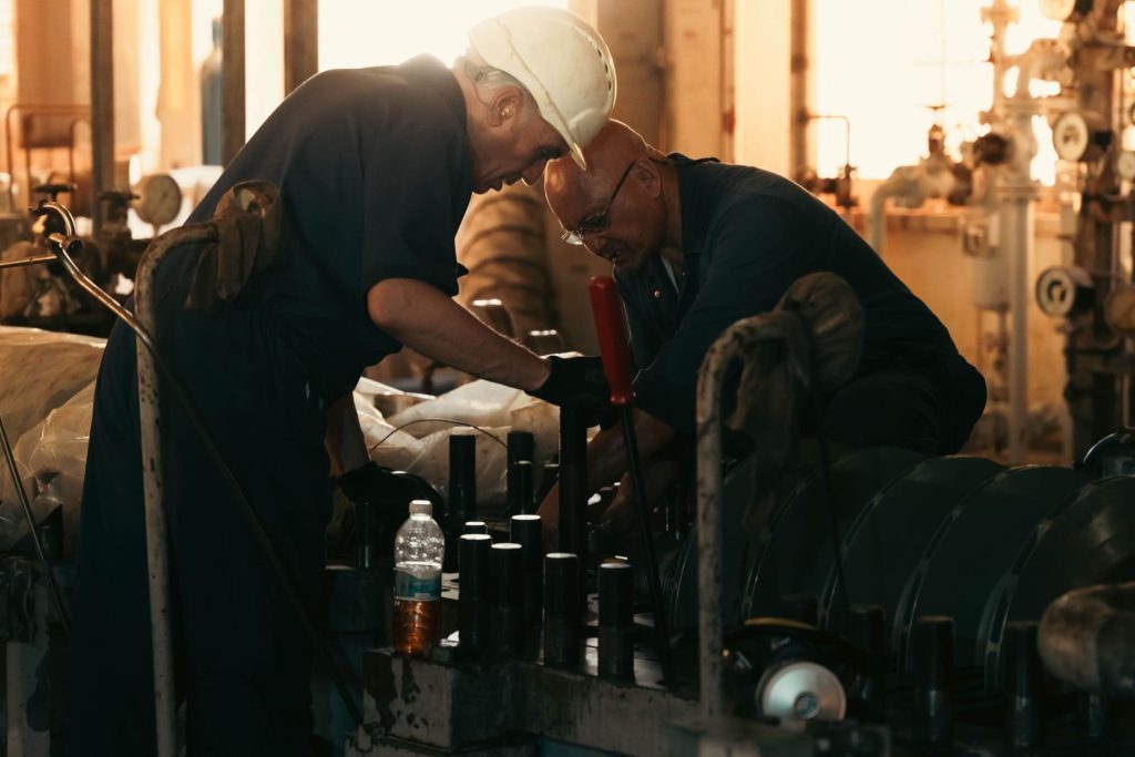 Deux techniciens de maintenance industrielle intervenant sur une machine